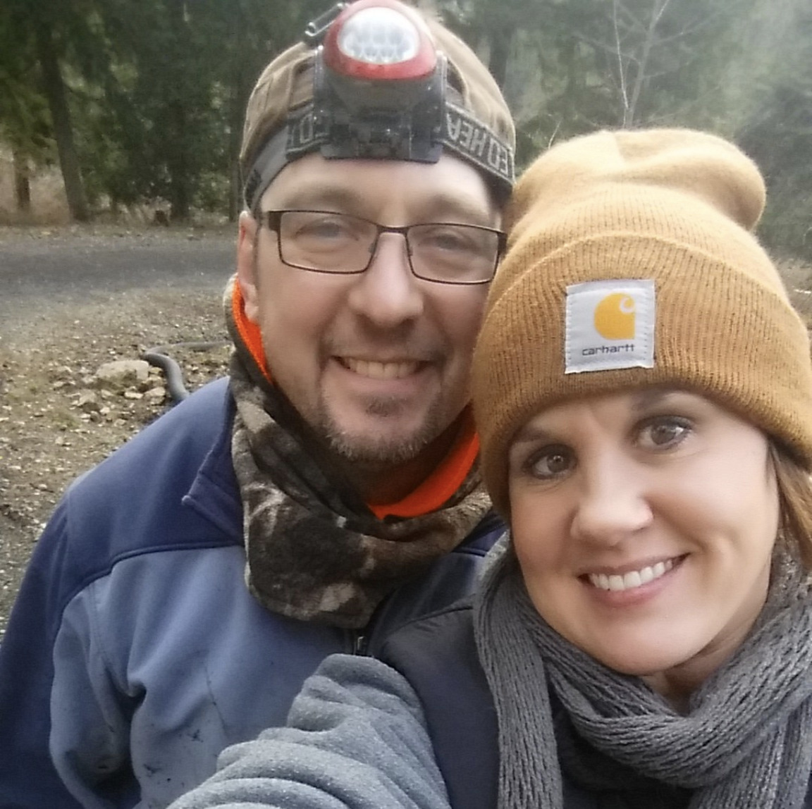 Jaimie and Dave, owners of Highland & Co. Acres farm, smiling together outdoors in winter clothing during outdoor adventure